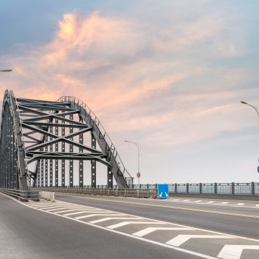 steel bridge and road with sunset sky
